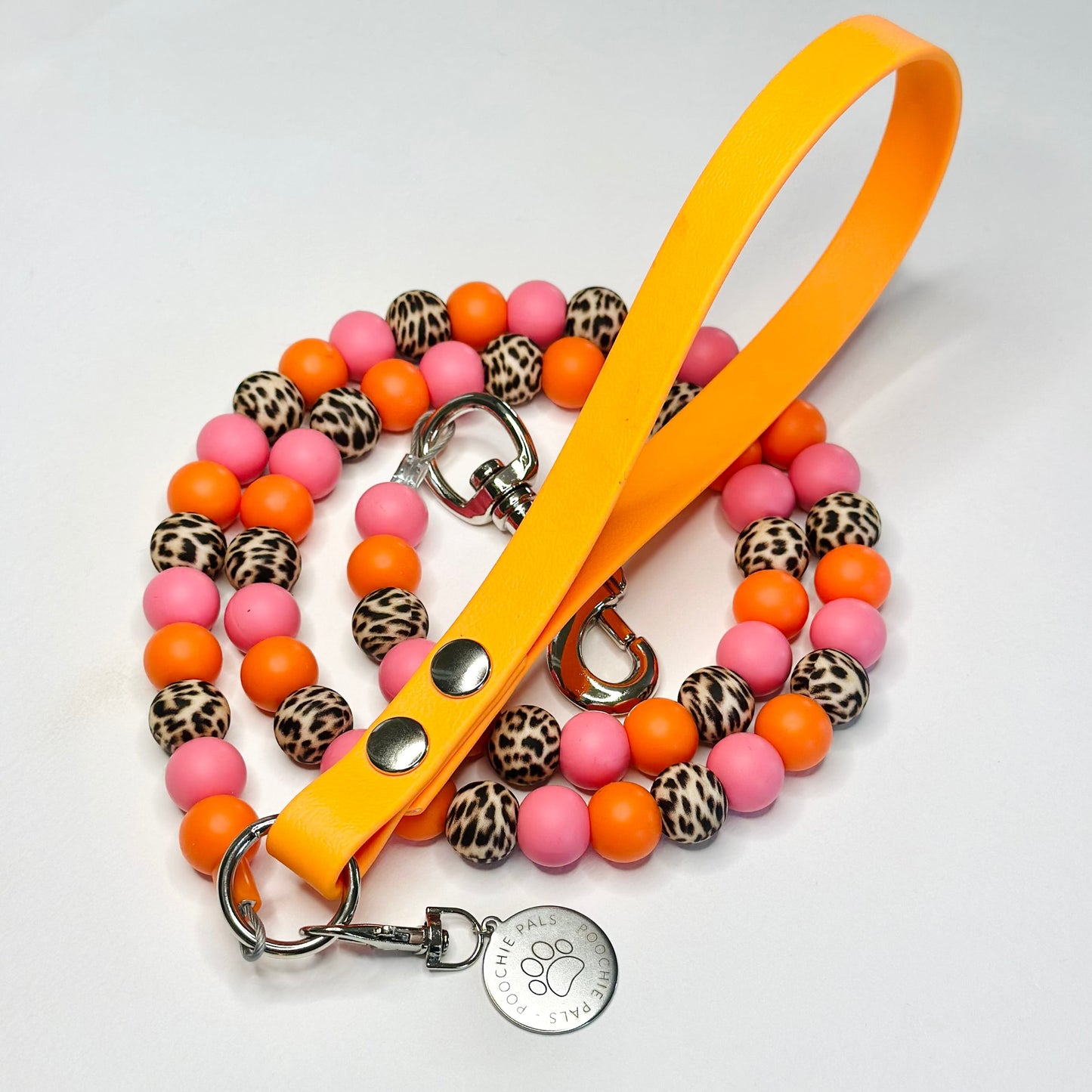 Dog leash with colorful beads and a yellow handle on a light gray background