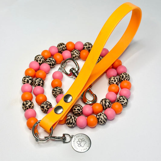 Dog leash with colorful beads and a yellow handle on a light gray background