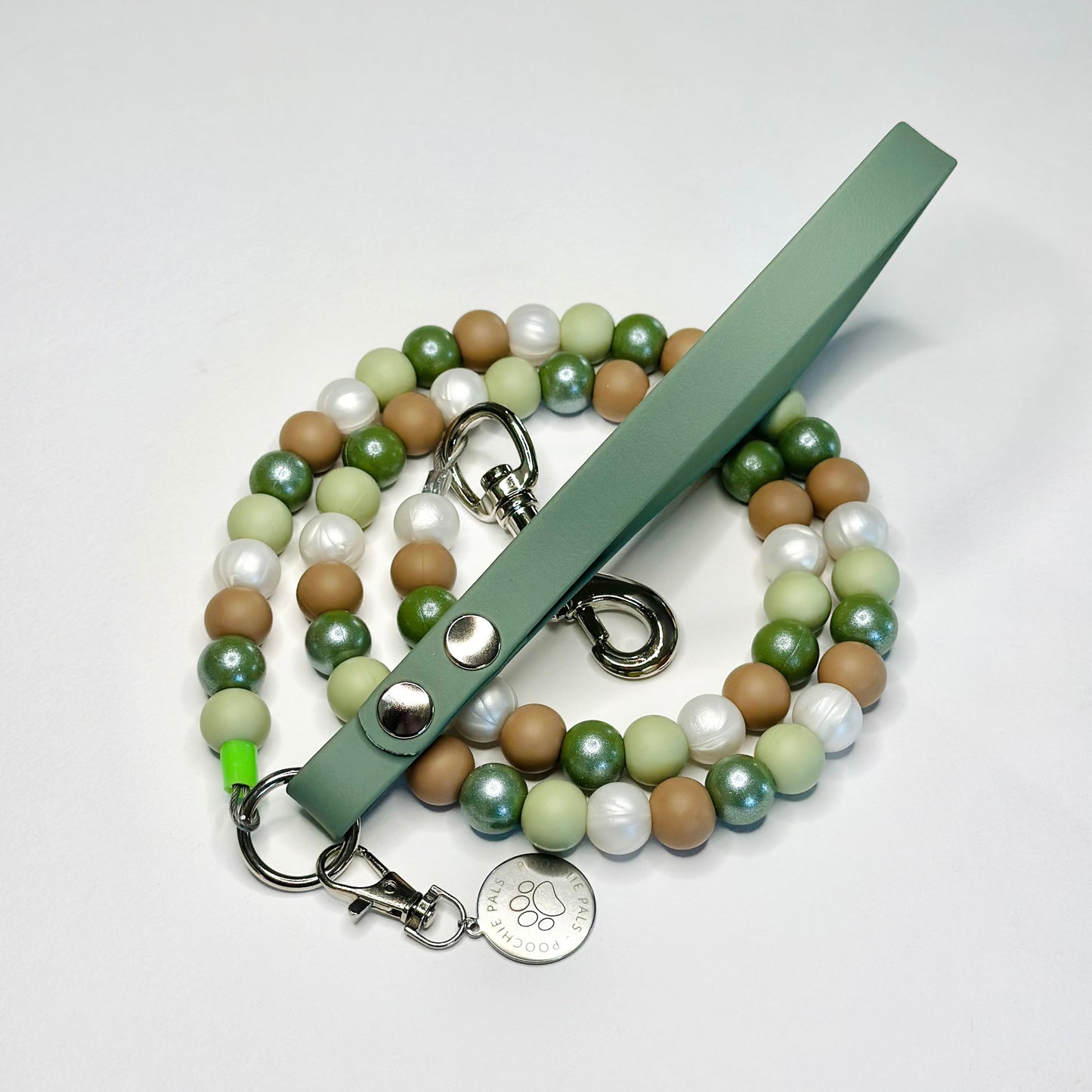 Beaded leash with a green handle on a white background