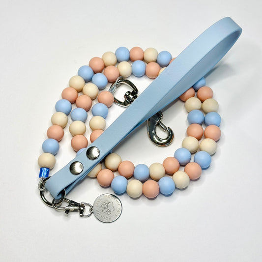 Pastel beaded leash with a light blue leather handle on a white background