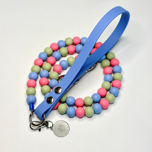 Multicolored beaded leash with a blue handle on a white background