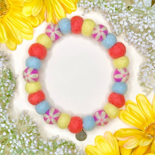 Colorful beaded bracelet on a decorative background with flowers