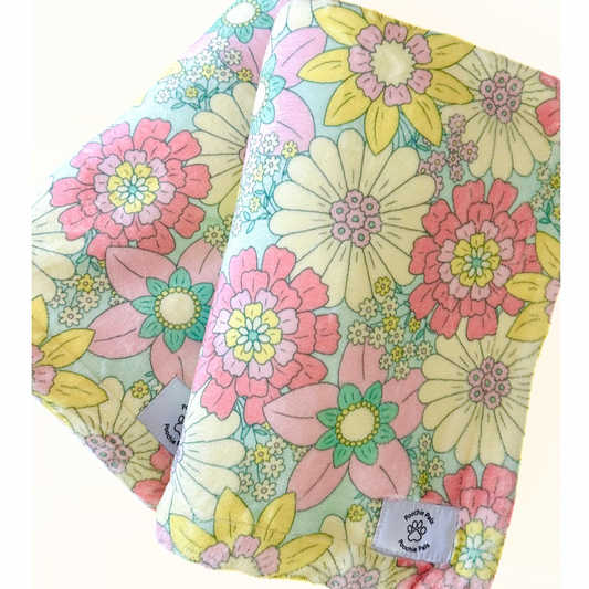 Two floral-patterned fleece blanket for dogs with a visible brand label on a white background
